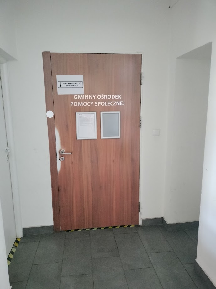Na zdjęciu drzwi z napisem Gminny Ośrodek Pomocy Społecznej
